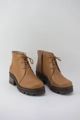 Borcego color suela de cuero con plataforma tractorada, cordones y cierre lateral.