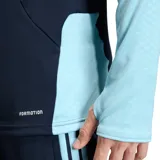 Buzo de entrenamiento de manga larga de la Selección Argentina, color azul marino con detalles en celeste claro. Presenta cuello alto con cierre frontal parcial, logo de Adidas y escudo de la AFA en el pecho. Las mangas tienen tres franjas celestes y paneles celestes texturizados en los antebrazos.