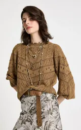 Sweater de punto color camel con diseño calado geométrico, cuello redondo y mangas largas con volumen suave. Presenta puños y dobladillo acanalados.