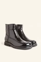 Bota corta de cuero vacuno con acabado charol brillante, diseño de punta cuadrada y suela de caucho con pequeña plataforma.