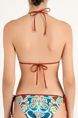 Top de bikini estilo triángulo con tirantes finos ajustables para atar al cuello y a la espalda. Presenta un estampado colorido en tonos terracota, turquesa y blanco, con detalles de apliques metálicos dorados.