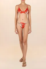 Calzón de bikini color naranja con estampado de hojas en tonos beige y marrón.