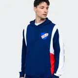 Canguro deportivo Umbro del Club Nacional de Football, color azul con paneles laterales blancos y detalles en rojo. Cuenta con capucha con cordones ajustables, bolsillo frontal tipo canguro y escudo del club estampado en el pecho.
