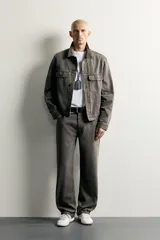 Cazadora de denim de algodón en color gris oscuro con efecto lavado, corte relaxed fit, cuello camisero, bolsillos delanteros con solapa en el pecho y cierre frontal con botones.