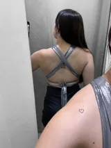 Top negro con escote halter y tiras cruzadas en el abdomen.