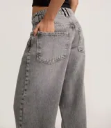 Pantalón skater de jean color gris con lavado dirty, tiro bajo, trabillas anchas en la cintura y bolsillos diferenciados.