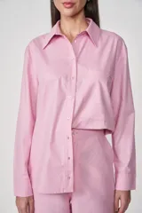 Camisa rosa de manga larga con cuello clásico, cierre frontal con botones y bolsillo en el pecho.