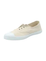 Zapatilla tipo sneaker de estilo clásico, confeccionada en algodón orgánico color beige con puntera reforzada y suela de goma blanca. Presenta un diseño ligero y transpirable con ajuste elástico.