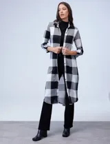 Camisa larga de cuadrillé roja, negra y gris, de la marca New York Laundry. Tiene cuello con solapa, abertura central con botones, mangas largas regulables con presilla y botón, y tajos laterales.