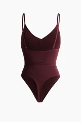 Body tanga modelador color borravino con efecto vientre plano y copas sin aros que realzan el busto. Cuenta con breteles finos ajustables y diseño sin costuras laterales.
