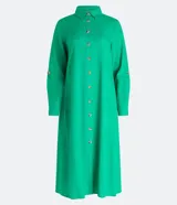 Vestido chemise largo color naranja, confeccionado en viscolino. Tiene cuello solapa, cierre con botones, manga larga con martingale, aberturas laterales y no tiene estampado.