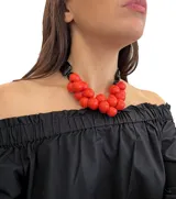 Collar corto de cuentas de resina rojas y negras, con cierre de mosquetón y cadena para regular el largo.