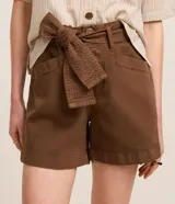 Short corto de sarga en color beige, con tiro medio, bolsillos laterales y cinturón incorporado del mismo tejido para atar en la cintura.