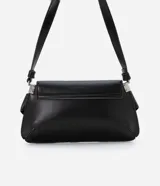 Cartera tipo baguette de tamaño pequeño, confeccionada en poliuretano color negro. Presenta una solapa frontal con detalles de hebillas metálicas decorativas en los laterales y un asa de hombro ajustable.