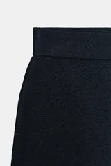 Minifalda de tiro alto en tejido de punto negro, con cintura elástica y diseño de bajo con terminación en ondas.