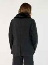 Chaqueta de gabardina color tostado con cuello de piel sintética en tono marrón, cierre frontal con botones y bolsillos delanteros con solapa.