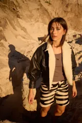 Campera de cuero oversize con solapa amplia de corderito, mangas anchas y detalle de cuero trenzado en la parte delantera.