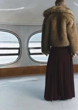 Falda larga bordó de tiro medio, confeccionada en viscosa, con diseño fluido, detalle de godets y cierre de cremallera lateral. Incluye forro interior y cinturón ancho con hebilla metálica circular.