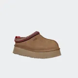 Zuecos UGG modelo Tazz de gamuza color marrón, con suela de plataforma alta y detalle de trenzado decorativo en el borde superior.