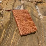 Billetera Shika mini de cuero vacuno color marrón con textura tipo piel de cocodrilo.