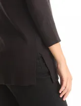 Buzo de tejido fino en color negro, con cuello redondo decorado con apliques de strass. Presenta mangas tres cuartos con puños acanalados y aberturas laterales en el ruedo.