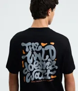 Remera negra de algodón con estampado psicodélico y lettering "The Wild Doesn't Wait" en el frente y la espalda. Diseño de corte comfort, cuello redondo y manga corta.