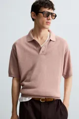 Polo relaxed fit de punto tejido en hilatura con algodón y viscosa, color rosado. Cuello solapa con cierre frontal de botonadura y manga corta. Acabados en rib.