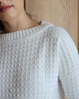 Sweater de punto color verde claro con textura tipo waffle, cuello redondo y mangas 3/4.