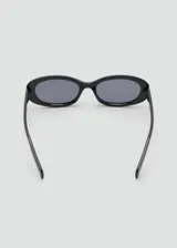 Lentes de sol con montura de policarbonato y diseño alargado de inspiración futurista, color negro.