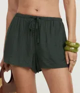 Short de playa color beige, confeccionado en viscosa y poliamida, con diseño holgado, bolsillos laterales, cintura elástica con cordón de ajuste tipo lazo y detalle de botones frontales.