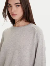 Sweater de tejido de punto color gris claro, con cuello redondo, mangas largas y terminaciones acanaladas en puños y ruedo.