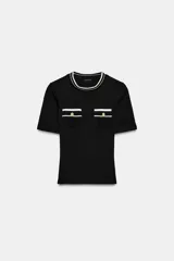 Camiseta negra de manga corta y corte slim fit, con cuello redondo ribeteado en blanco y dos bolsillos de plastrón en el pecho con un botón dorado cada uno.