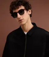 Campera masculina de estilo casual con cuello inglés, cierre frontal por cremallera, bolsillos laterales y ajuste elástico en el bajo. Presenta detalles de recortes en la parte superior delantera.