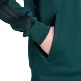 Campera deportiva Adidas First TT de poliéster reciclado color verde con rayas horizontales negras en el pecho y mangas raglán negras. Cierre frontal con cremallera, cuello alto y logo de Adidas bordado en el pecho.