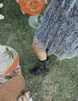 Botas de cuero color marrón y blanco con bordados negros, de estilo cowboy con taco bajo.