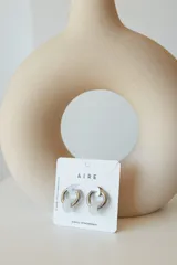Aros de argolla en acero quirúrgico con dije de piedra natural en tono azul.