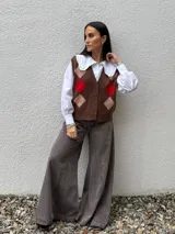 Chaleco tejido con diseño de rombos en color chocolate, con botones frontales y cuello en V.