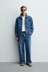 Cazadora de denim de algodón con cierre frontal de cremallera, cuello solapa y un bolsillo plastrón en el pecho. Presenta un diseño de corte regular con efecto lavado.