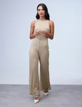 Enterito largo de gasa lurex plisada color dorado, con escote halter, cintura elastizada con punto smock, abertura en la espalda con cierre invisible y forro interno a tono.