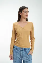 Remera color ocre de corte ajustado, con escote en V y botones.