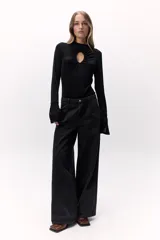 Pantalón de denim fino color negro con un dejo de marrón, tiro medio y pata ancha con costuras a contratono.