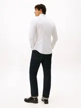 Camisa de manga larga Tommy Hilfiger con corte slim, confeccionada en algodón. Presenta un estampado de micro puntos, cuello clásico y cierre frontal con botones. Incluye el logo de la marca bordado en el pecho.