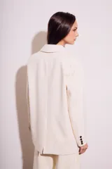 Blazer color crema de poliéster y viscosa, de corte oversize con solapas y doble botonadura.