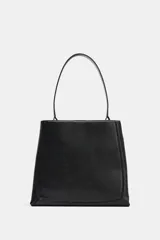 Bolso de hombro formato saca, color negro, con detalle de pespuntes en el cuerpo, asa de hombro y cierre mediante botón imantado.