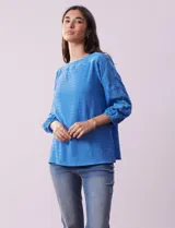 Blusa amarilla texturada con escote redondo y mangas 3/4 con puño elastizado. Aplique de broderie en escote y mangas. Marca Ruby Rd.