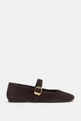 Zapato plano tipo bailarina confeccionado en serraje, con punta redonda y tira delantera ajustable con maxi hebilla metálica dorada.