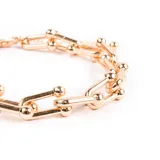 Pulsera dorada con eslabones en forma de U unidos por esferas.