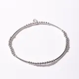 Pulsera de plata con cuentas esféricas y detalle de dije circular.