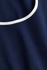 Musculosa corta de punto de algodón, color azul marino, con escote redondo profundo y ribete blanco en el escote y sisas.