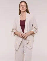 Chaqueta liviana color beige de silueta fluida y diseño abierto, con solapa caída, cintura con cordón ajustable y mangas 3/4 con presilla y argolla metálica.